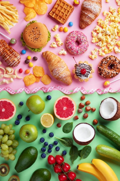 Healthy and unhealthy food background from fruits and vegetables vs fast food, sweets and pastry top view. Diet and detox against calorie and overweight lifestyle concept separated with measuring tape.